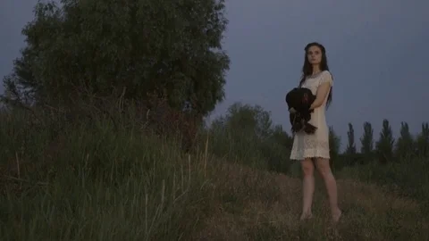 A Girl In A White Dress Stands At Nature With a Rooster In Hands Stock Footage