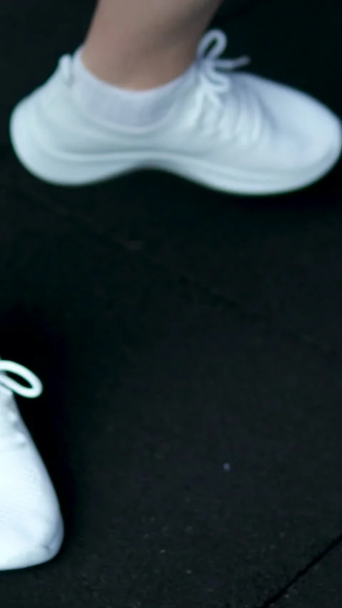 Girl in white sneakers develops ankle and hip joints. hip joint circular Video stock 305978419