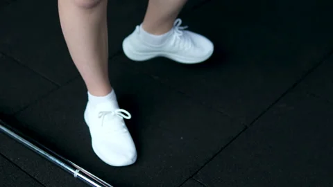 Girl in white sneakers develops ankle and hip joints. hip joint circular Video stock 305991261