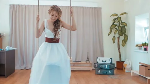 Girl in White on a Swing in the Studio Stock Footage 68660733