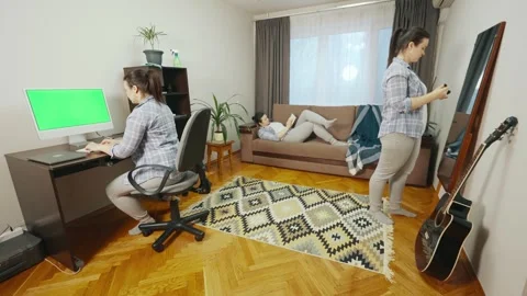 A girl who simultaneously works at a computer, reads a book and does makeup. Stock Footage 242626662
