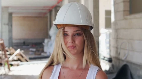 Girl is working and smiling at the construction site wearing helmet Stock Footage 80357532