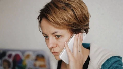 The girl working at the computer and talking on the phone Video stock 98746390