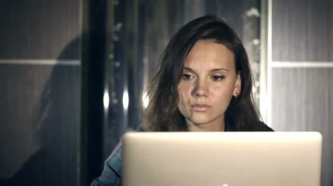 Girl working on computer in the evening in the interior with water background Stock Footage 42046168