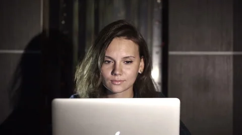 Girl working on computer in the evening in the interior with water background Stock Footage 42046849