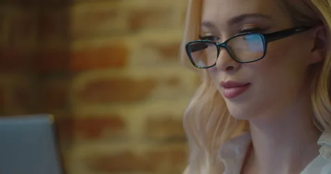 Girl working in the glasses on the computer screen. Woman sitting in cafe Stock Footage 149988395