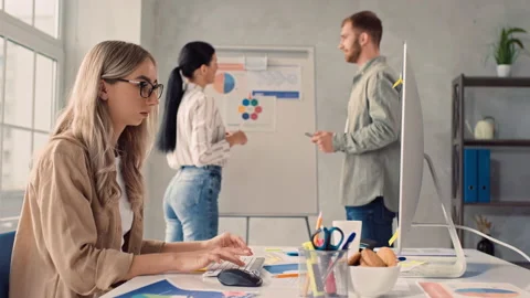 Girl Working on PC in Creative Office. Team Discussing Presentation in Office Stock Footage 217827970