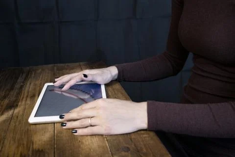 The girl working with a tablet computer. The graph rises. Table, wooden, back Stock Photos