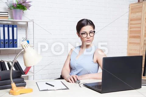The Girl Works In An Office At A Computer
