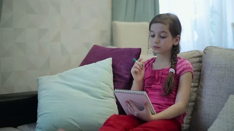 A girl writes and draws in Notepad Stock Footage 73359067