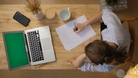 The girl writes down the main points from the conference. A laptop with a green  Stock Footage 148432918