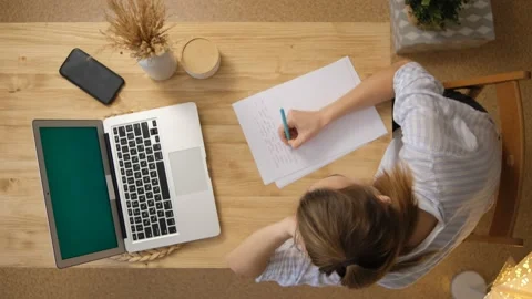 The girl writes down the main points from the conference. A laptop with a green  Stock Footage 148523074