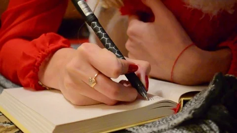 The girl writes the text in a notebook 库存影片 74395259