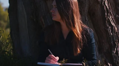 Girl Writes at a Tree Stock Footage 52177509