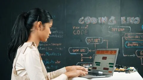 Girl writing code or engineering prompt while attend in STEM class. Edification. Stock Photos