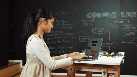 Girl writing code or engineering prompt while attend in STEM class. Edification. Stock Photos
