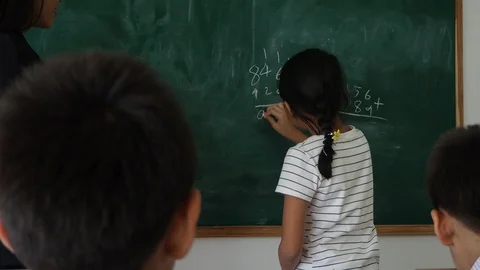 Girl writing math answer on board during lesson. Stock Footage 90245751