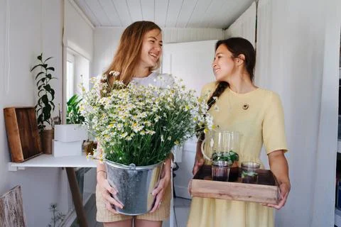 Girlfriends are having fun talking, they are holding lemonade and a bucket of da Stock Photos