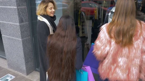 Girlfriends are looking at things in the storefront. Young girls are shopping. Stock Footage 81764670