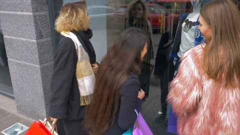 Girlfriends are looking at things in the storefront. Young girls are shopping. Stock Footage 81764871
