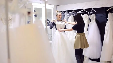 Girlfriends chooses wedding gown at bridal store Stock Footage 59083968
