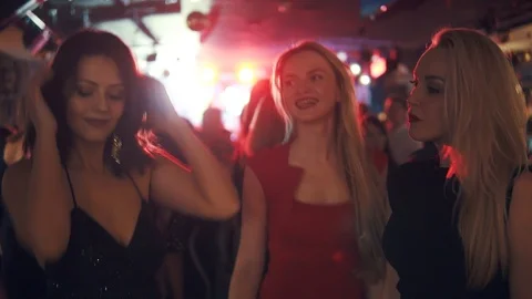 Girlfriends dancing in a crowd of people in a disco Stock Footage 101653231