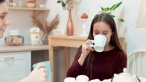 Girlfriends at dinner drinking tea with white cup and smiles Stock Footage 176337856