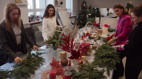 The girlfriends help each other create bouquets of fir branches and other Stock Footage 316069907