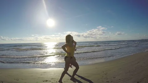 Girlfriends jogging along the beach Stock Footage 71996631