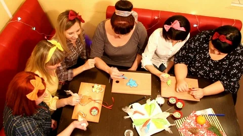 Girlfriends paint gingerbread and communicate for the holiday view from above Stock Footage 101326371