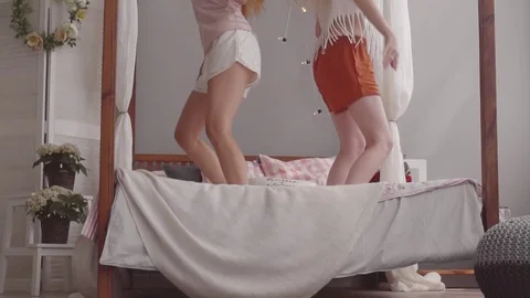 Girlfriends in pajamas have fun and dancing together in the bedroom on the bed Stock Footage 80266857