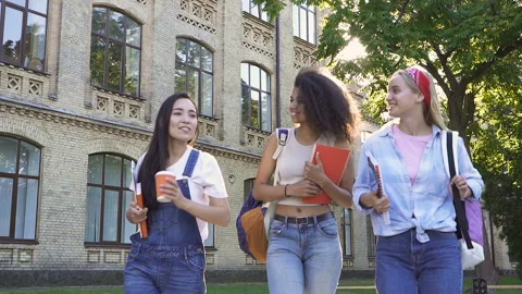 Girlfriends walking outside, talking with each other, smiling and laughing. Video stock 115728035