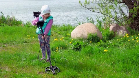 Girll looking for a ring with metal detector outdoors on the grass. Stock Footage 194818520