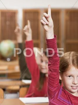 Girls (4-7) in classroom, raising hands, close-up Stock Photos