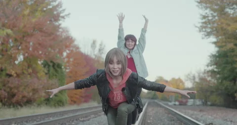 Girls Almost Balancing on Train Tracks Stock Footage 223400447