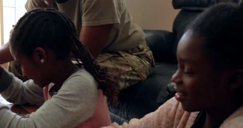 Girls assembling jigsaw puzzle with army soldier sister Stock Footage 220147594