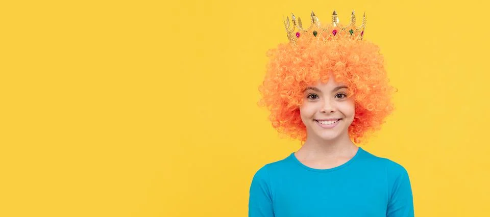 Girls birthday party. happy funny kid in curly wig and crown. imagine herself a Stock Photos