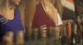 Girls chatting online using smartphones, wine bottles at nightclub bar counter 4k or 4k+ Resolution