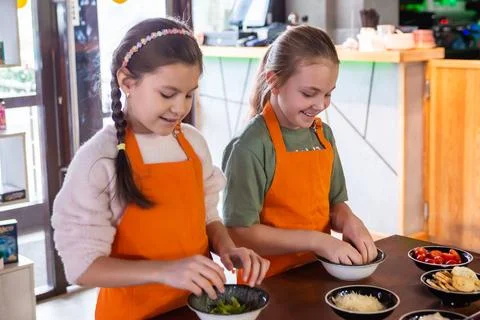 Girls at a culinary workshop on making Caesar salad in a restaurant. Foto stock
