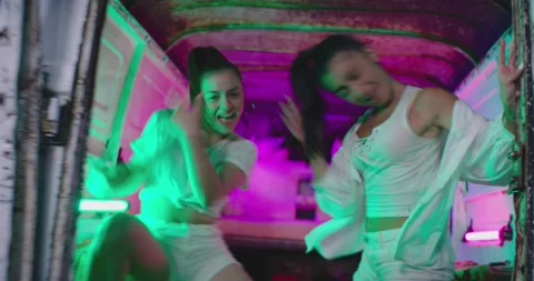 Girls dancing , moving , having fun inside trunk of old abandoned mini bus Stock Footage 158798560