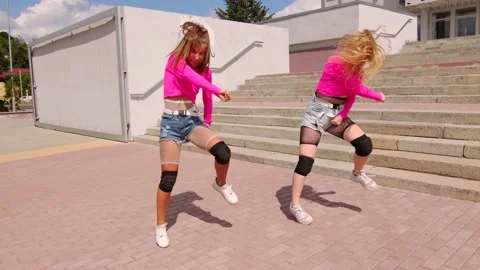 Girls dancing twerk and sit on the twine on the background of the building Stock Footage 139528126