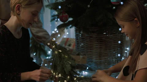 Girls decorate a small Christmas tree with cones. 動画素材 143474053
