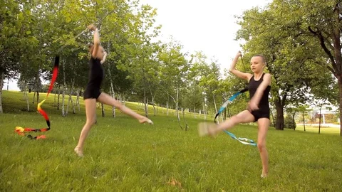 Girls engage in rhythmic gymnastics with Ribbon on the nature Stock Footage