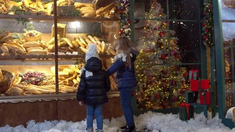 Girls examining bread in bakery window on Christmas day Stock Footage 143507684
