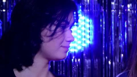 The girl's face is highlighted by a multi-colored searchlight Stock-Footage 99716234
