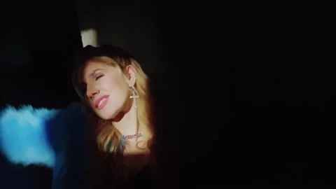 Girl's face in the rays of the sun in a dark room Vidéo 302540943