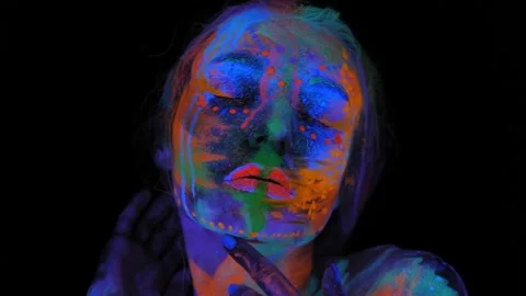 A girl's face with an ultraviolet pattern in the light of a fluorescent lamp. Stock Footage 197464906