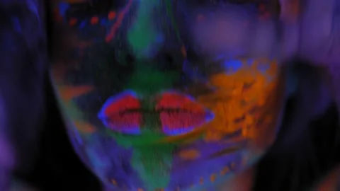 A girl's face with an ultraviolet pattern in the light of a fluorescent lamp. Stock Footage 197643376