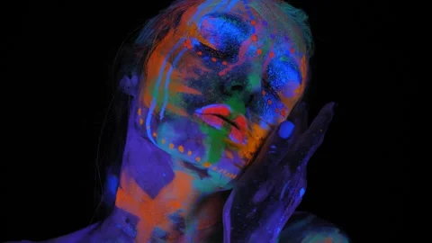 A girl's face with an ultraviolet pattern in the light of a fluorescent lamp. Stock Footage 265859729