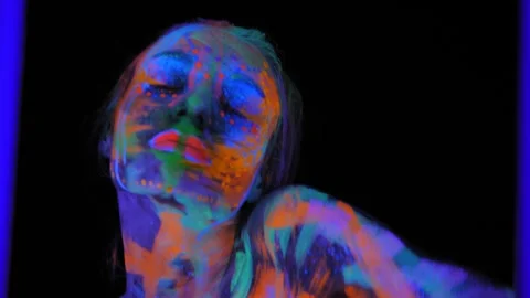 A girl's face with an ultraviolet pattern in the light of a fluorescent lamp. Stock Footage 266777307